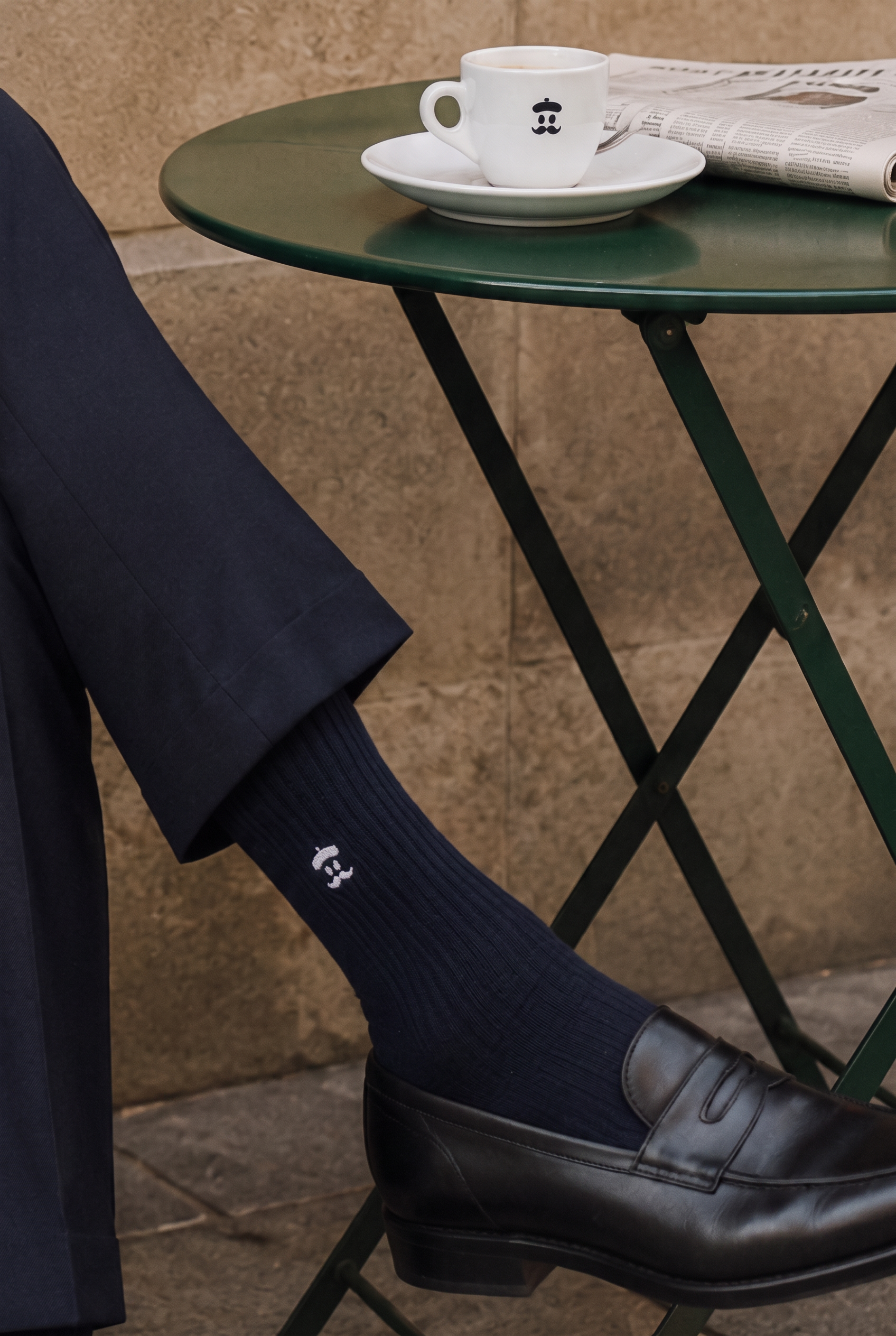 Midnight Sockrebleu socks worn with a tailored navy suit, leather loafers and an espresso at a café